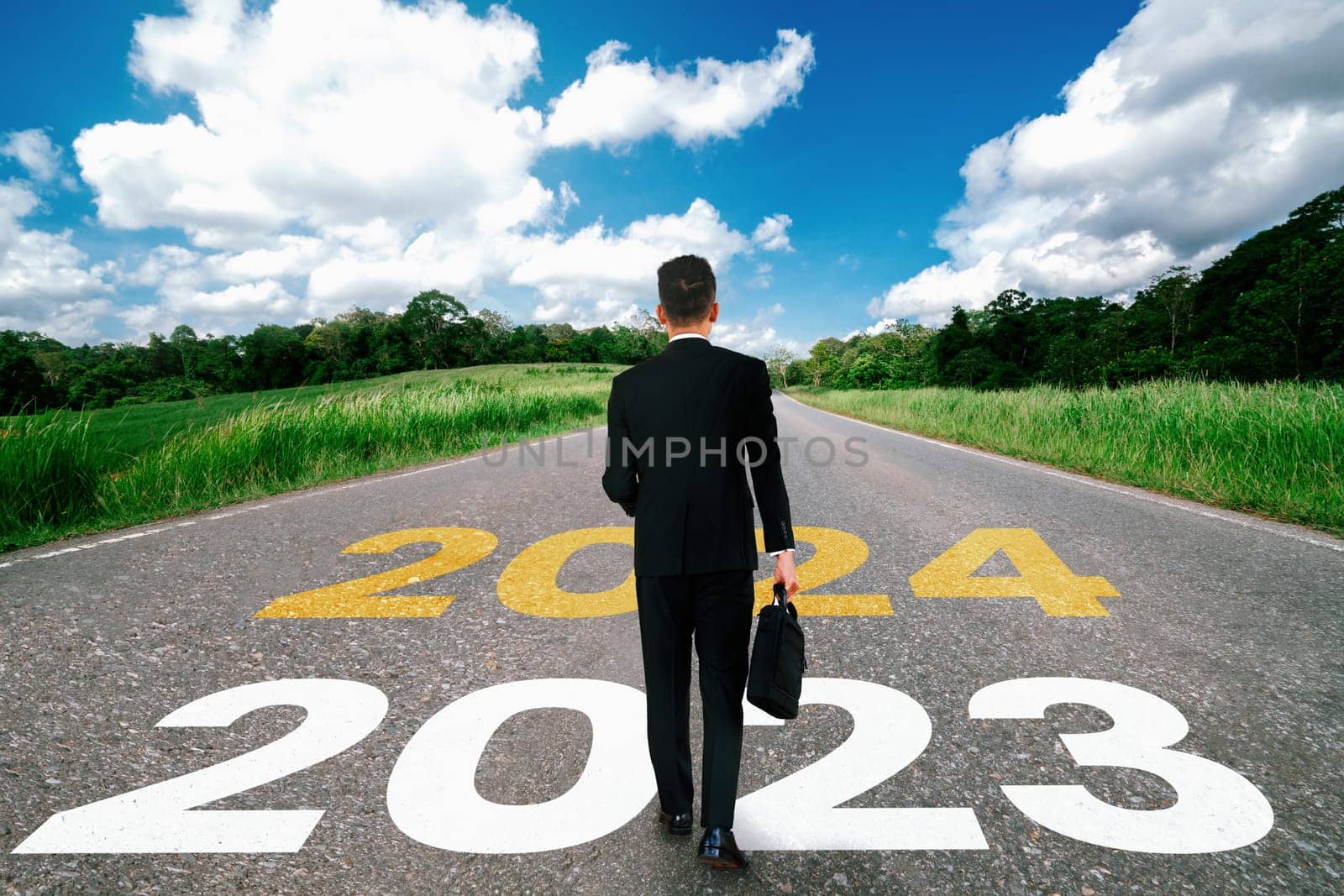 2024 New Year journey and future vision concept . Businessman traveling on highway road leading forward to happy new year celebration in beginning of 2024 for bliss and successful start .