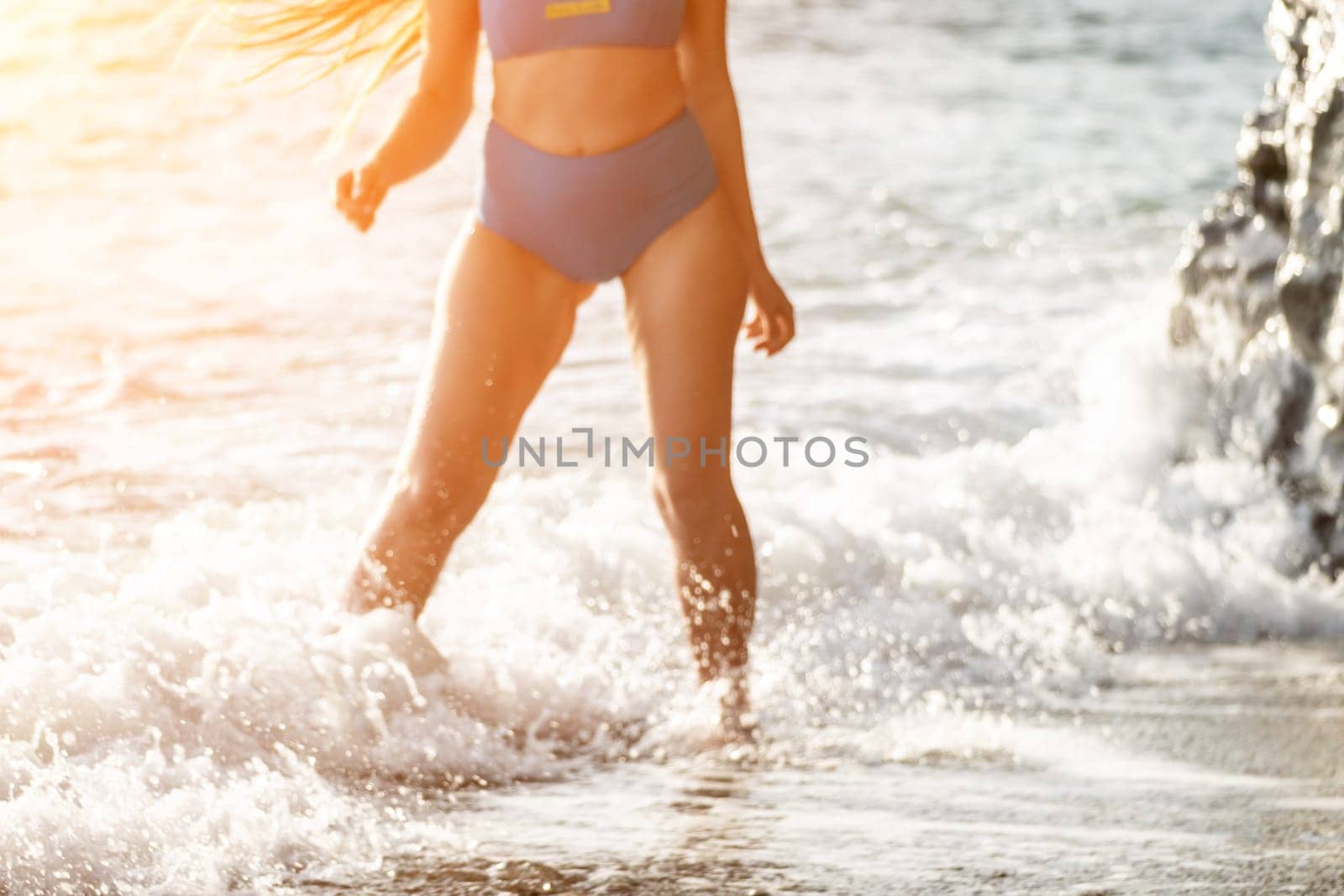 Running woman on a summer beach. A woman jogging on the beach at sunrise, with the soft light of the morning sun illuminating the sand and sea, evoking a sense of renewal, energy and health. by panophotograph