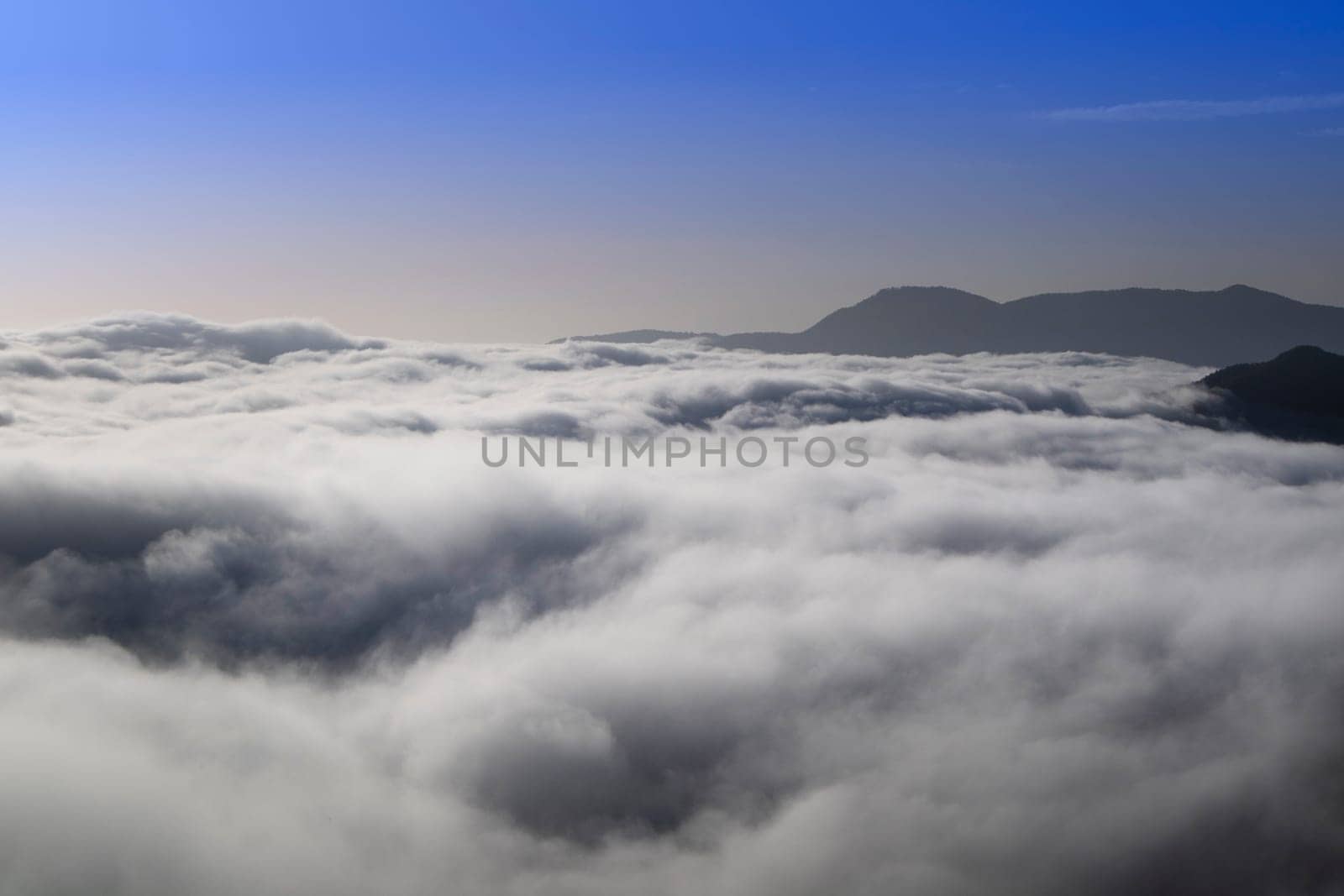 Photographic documentation of the moment when the fog rises in the valley early in the morning 