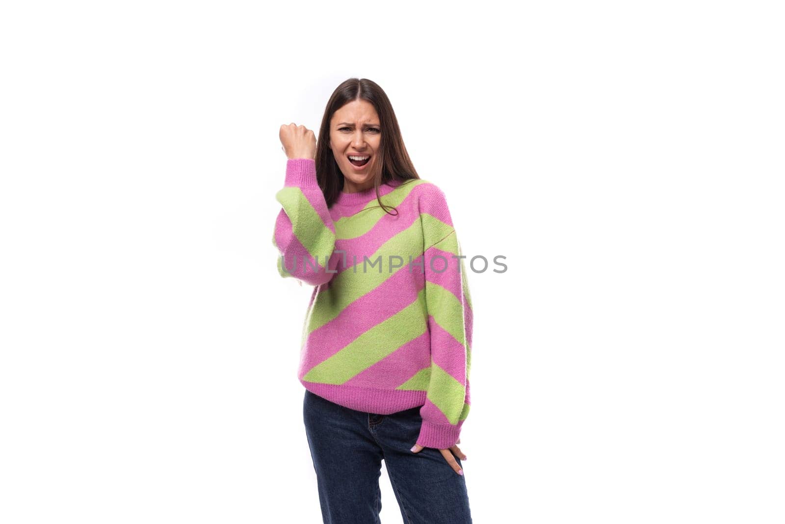 young happy caucasian woman with straight black hair is dressed in a stylish striped pink pullover.