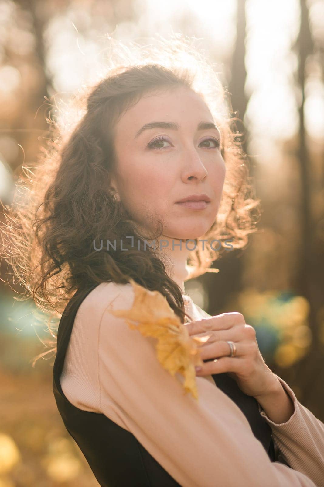 Portrait woman walking in autumn park, happy mood and fashion style trend and curly long brown hair copy space. Fall season and pretty female portrait copy space. Millennial generation concept by Satura86
