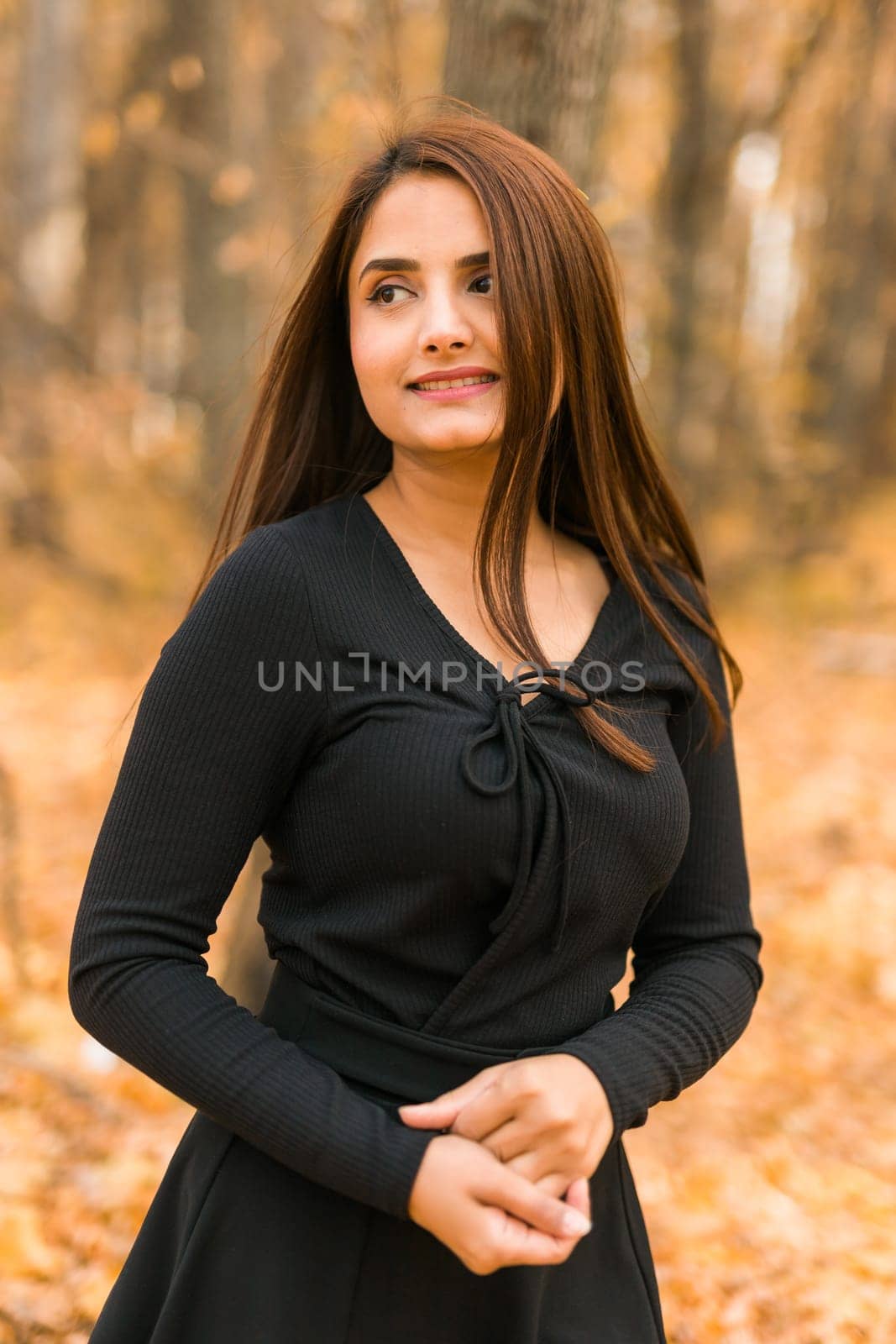 Close up portrait of pretty indian young woman enjoying warm autumn sunny day vacation outdoors. Generation z and gen z concept. Fall Season by Satura86