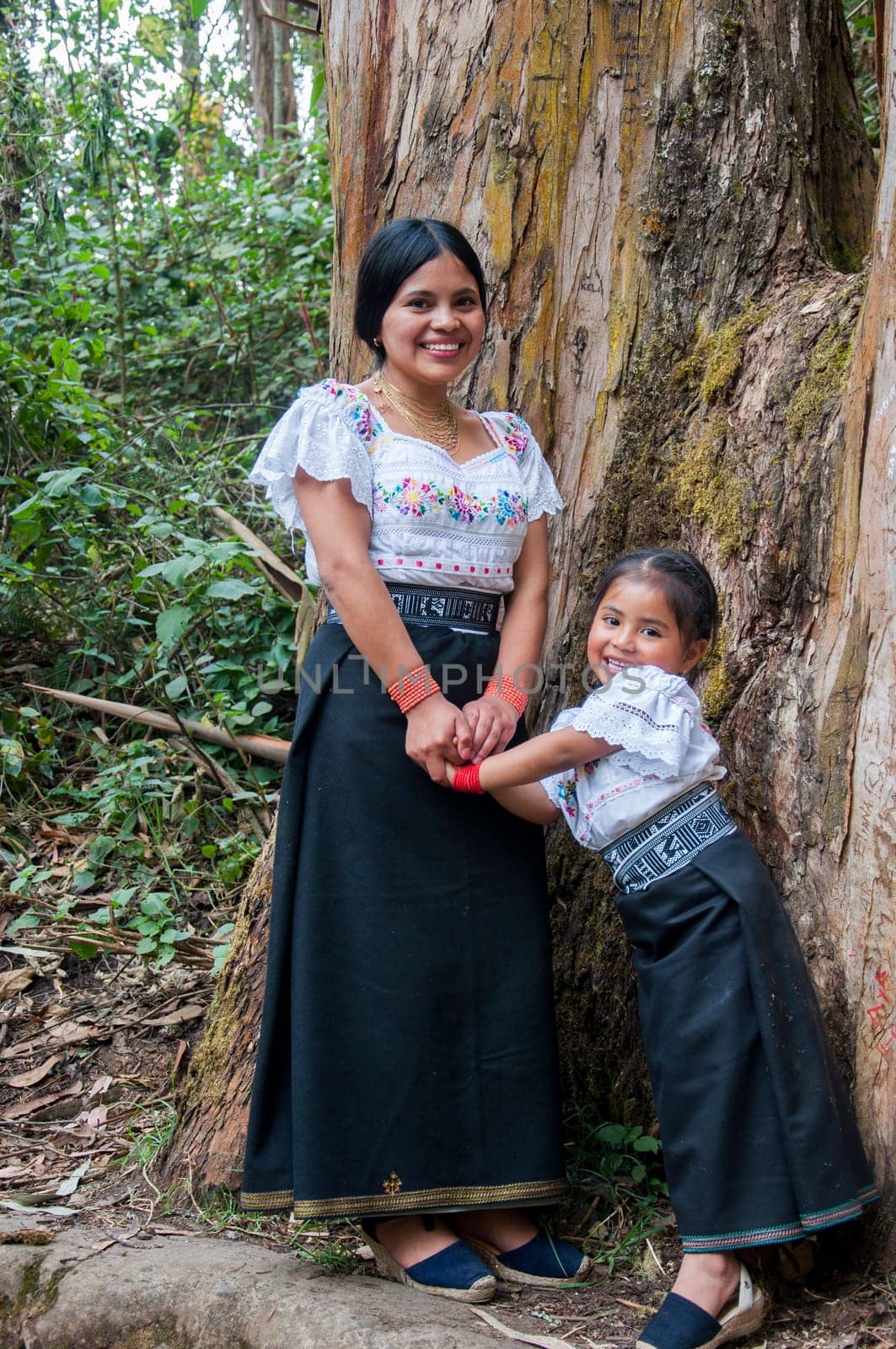 mother and daughter enjoying games together in the ecuadorian amazon with traditional dresses from otavalo. women's day. High quality photo