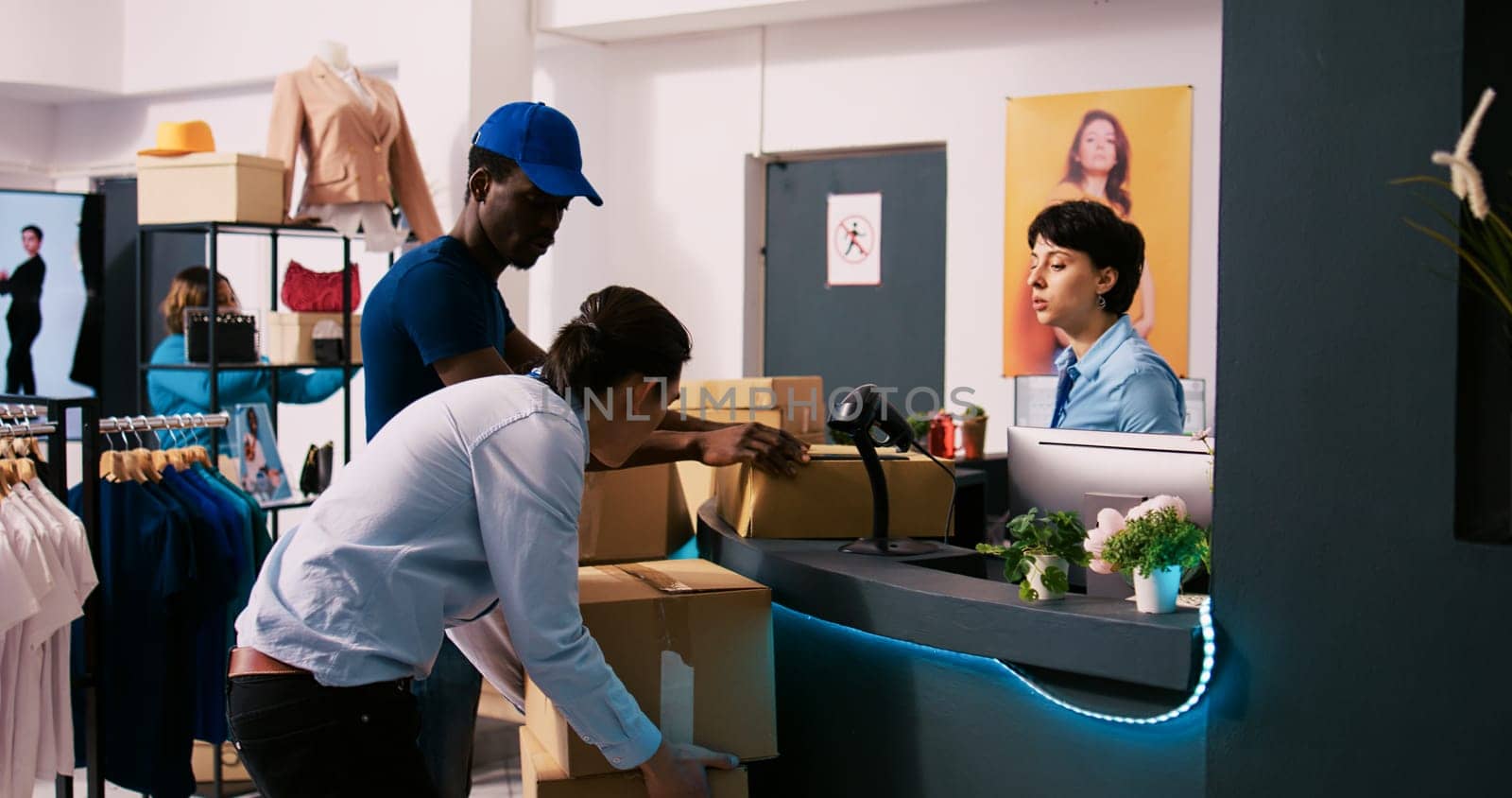 African american courier showing shipping report, discussing packages distribution in modern boutique. Stylish employee working at online orders, preparing trendy clothes for delivery in shopping mall