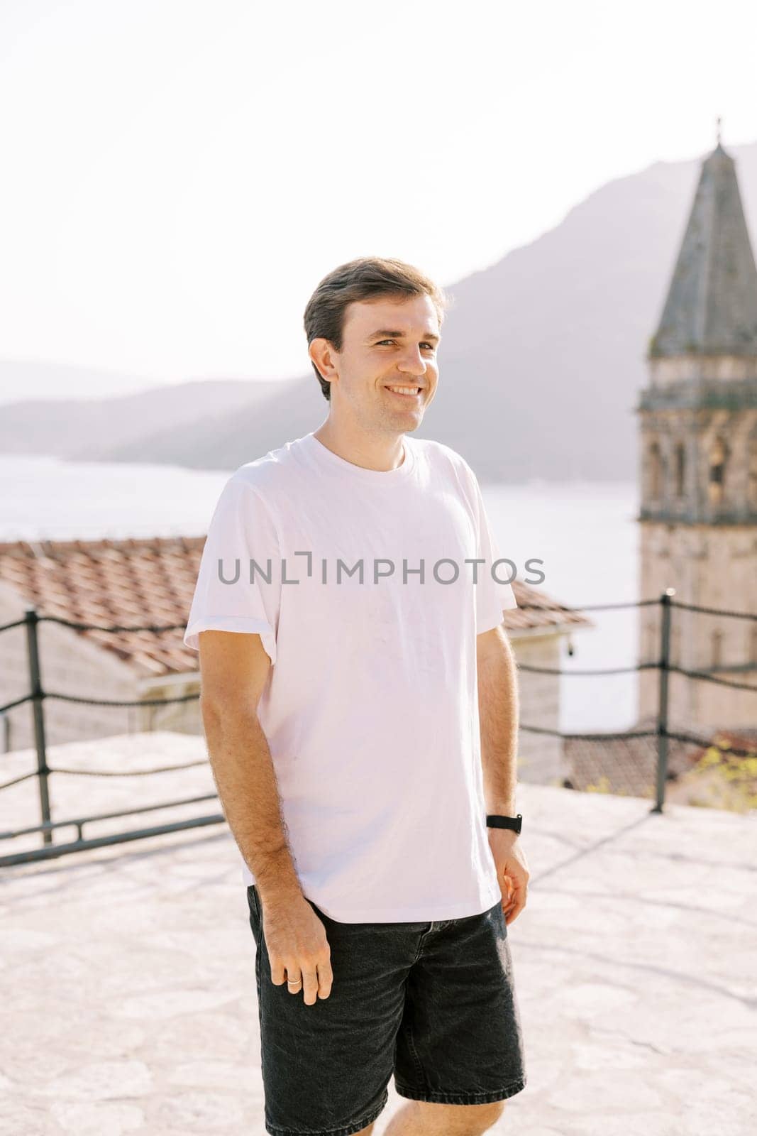 Smiling guy stands on the observation deck near the Church of St. Nicholas. Perast. Montenegro. High quality photo