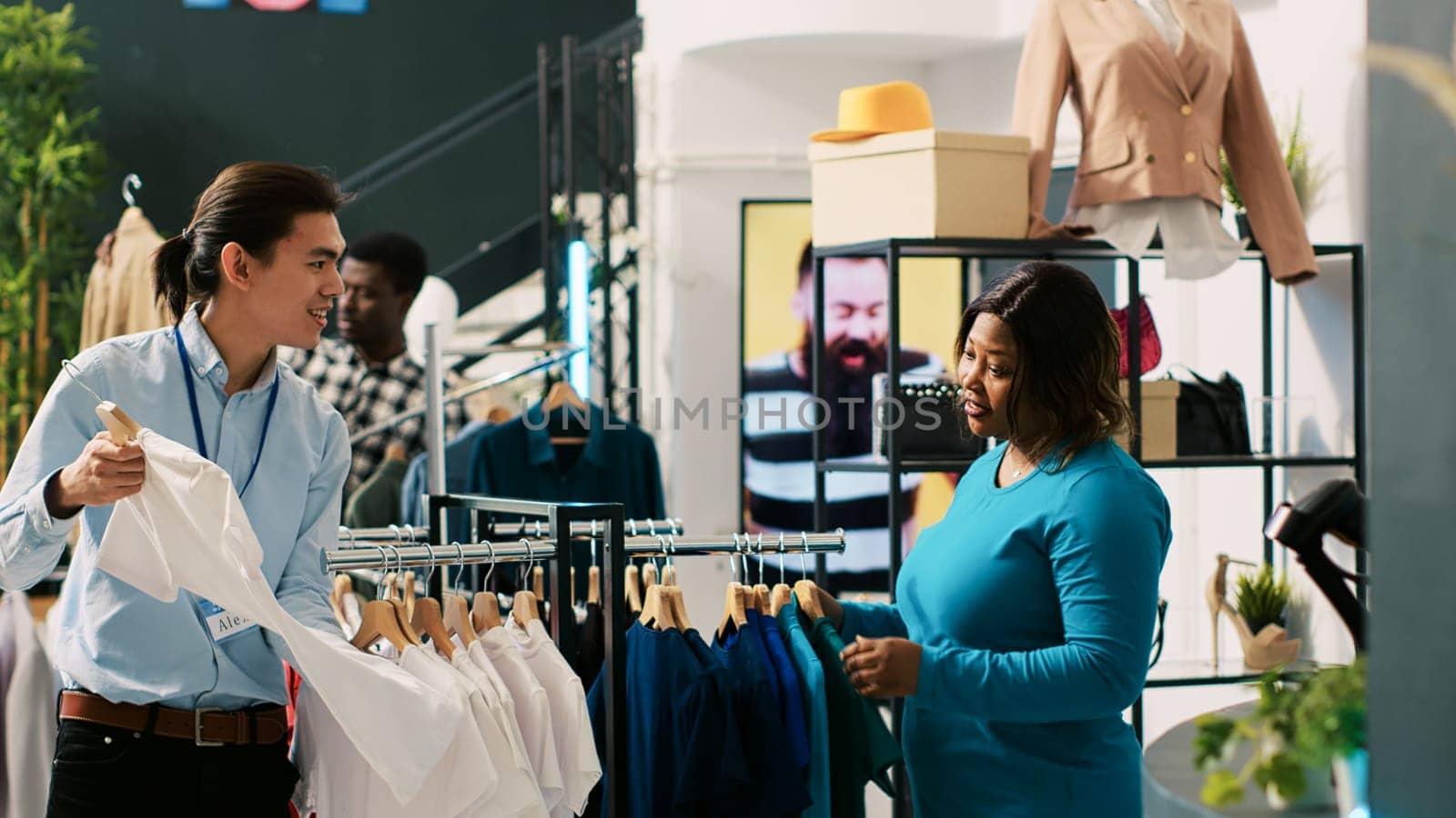 African american client checking stylish merchandise, discussing outfit fabric with store manager. Shopaholic woman buying fashionable clothes and accessories in modern boutique. Fashion concept