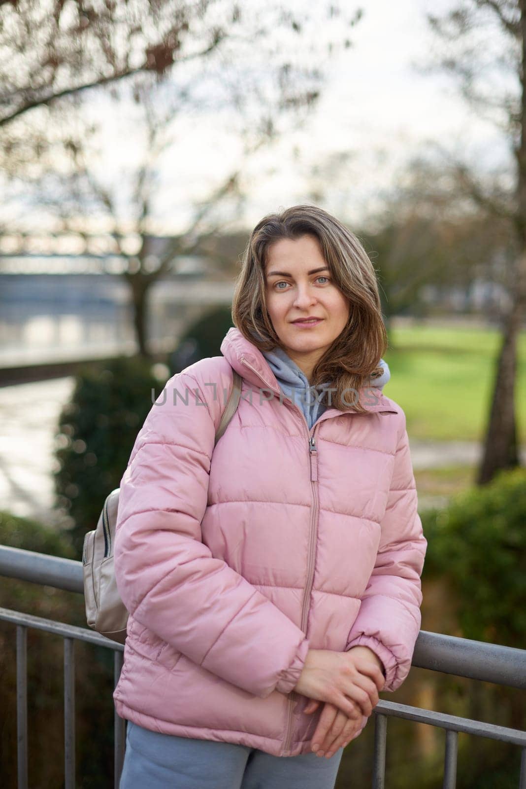 Young beautiful pretty tourist girl in warm hat and coat with backpack walking at cold autumn in Europe city enjoying her travel in Bietigheim-Bissingen, Deutschland. Outdoor portrait of young tourist woman enjoying sightseeing by Andrii_Ko