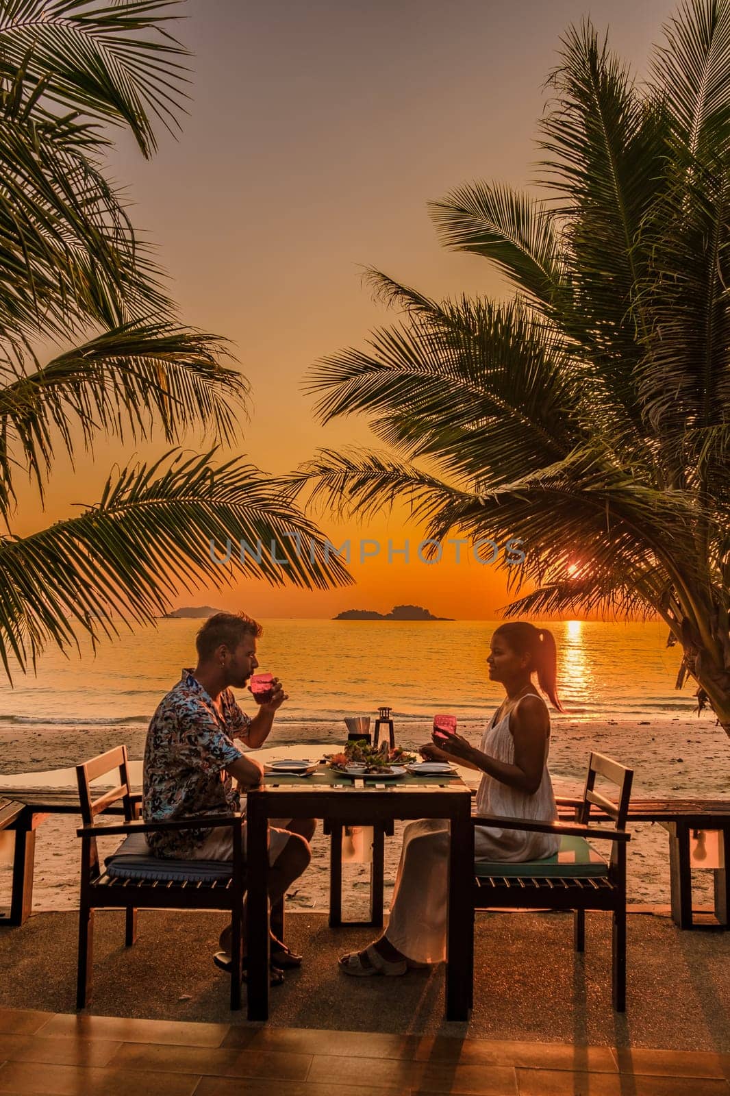 Tropical Island Koh Kood or Koh Kut Thailand. Couple men and women on vacation in Thailand having a romantic dinner at sunset on the beach, holiday concept Island hopping in Eastern Thailand Trang