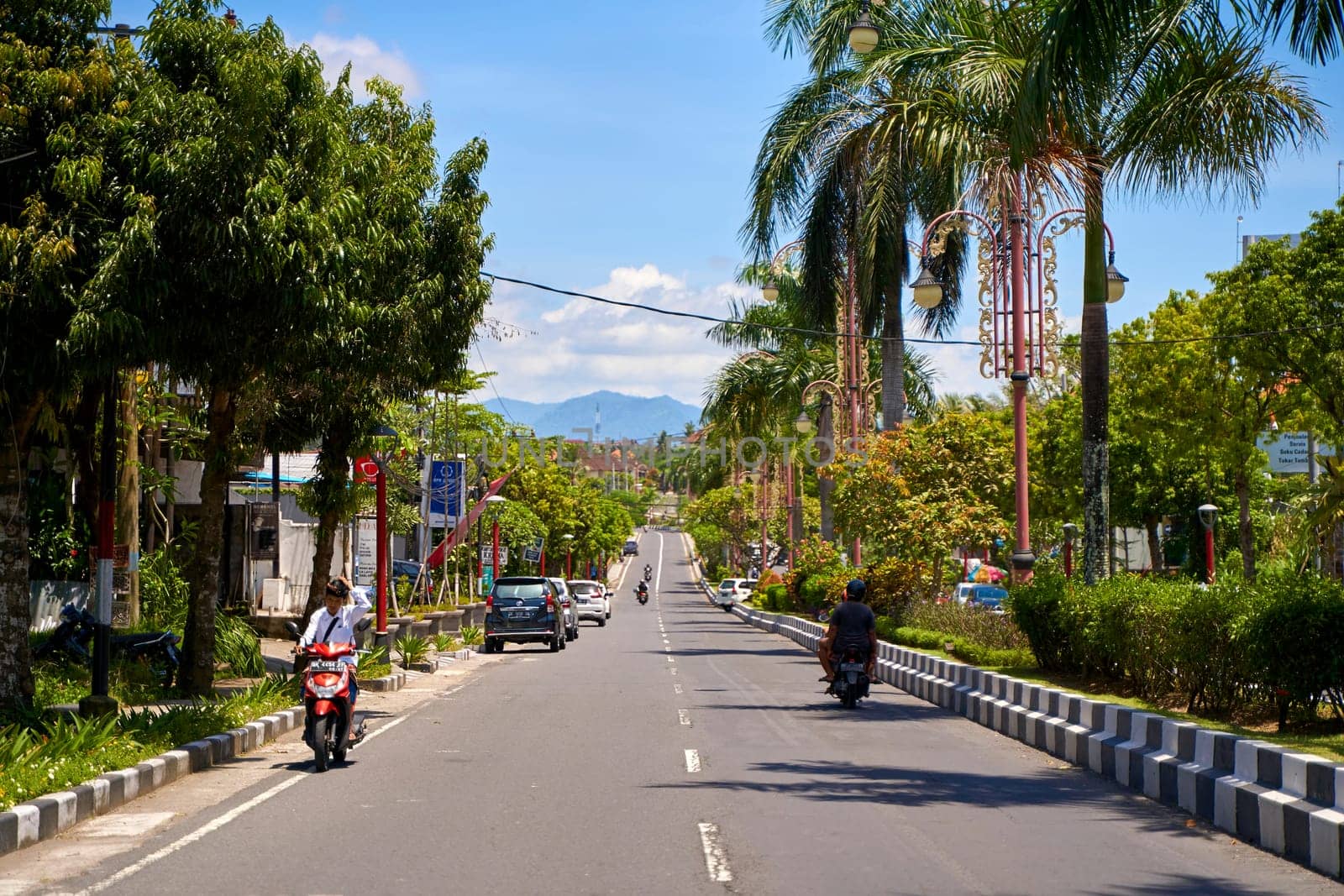 A person on a motorcycle rides a scenic asphalt road in Asia. Bali, Indonesia - 12.08.2022