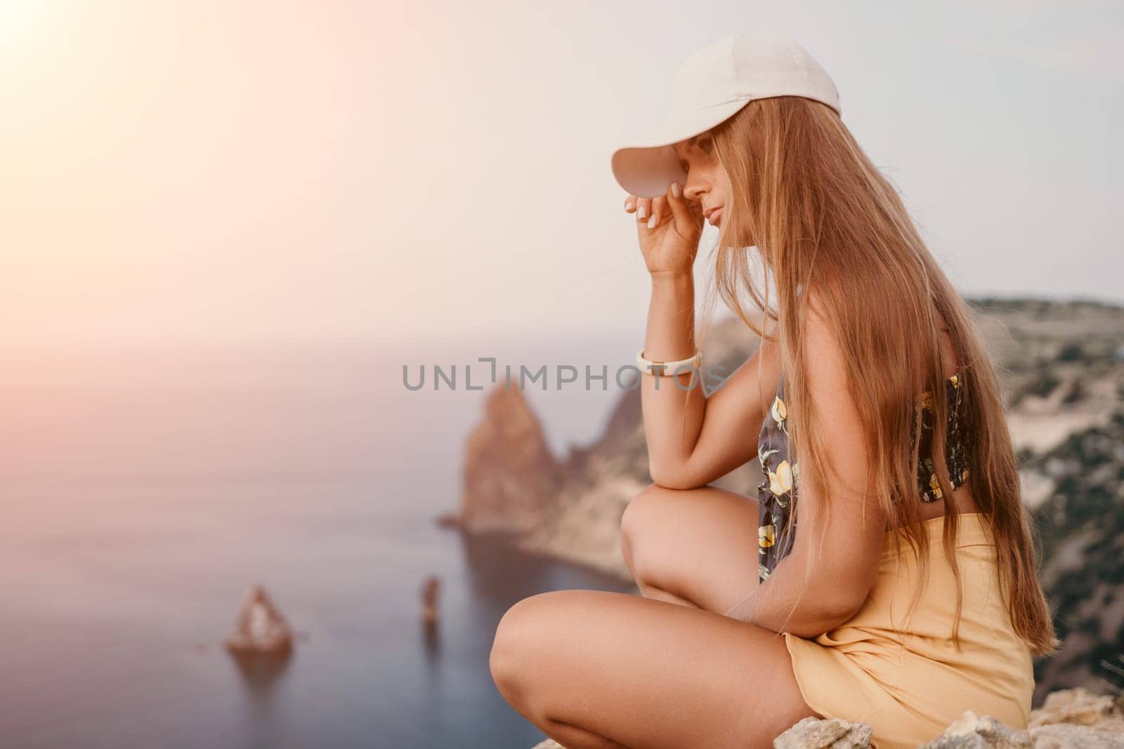 Woman travel sea. Happy tourist taking picture outdoors for memories. Woman traveler looks at the edge of the cliff on the sea bay of mountains, sharing travel adventure journey.