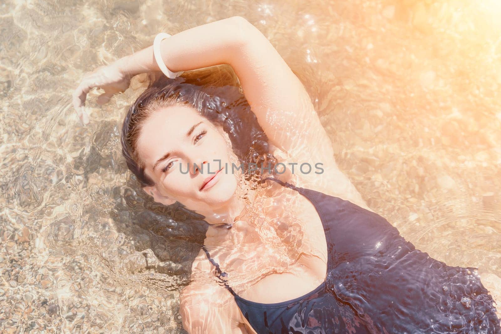 Woman travel sea. Young Happy woman in a long red dress posing on a beach near the sea on background of volcanic rocks, like in Iceland, sharing travel adventure journey