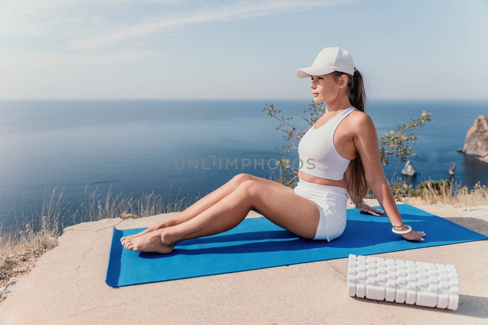 Fitness woman sea. Outdoor workout on yoga mat roller in park near to ocean beach. Female fitness pilates yoga routine concept. Healthy lifestyle. Happy fit woman exercising with rubber band in park. by panophotograph