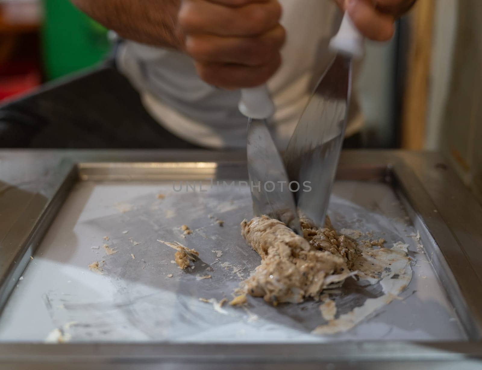 A craftsman makes rolled ice cream on a cold plate with skill.