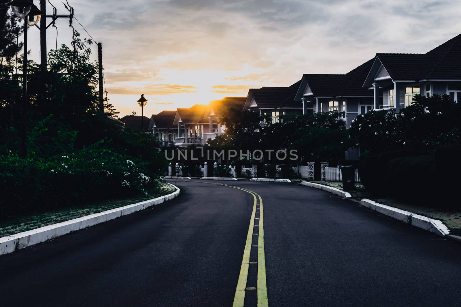 Modern cottages row road sidewalk two story buildings residential villas village New Estate Reflection dawn Sun in windows.