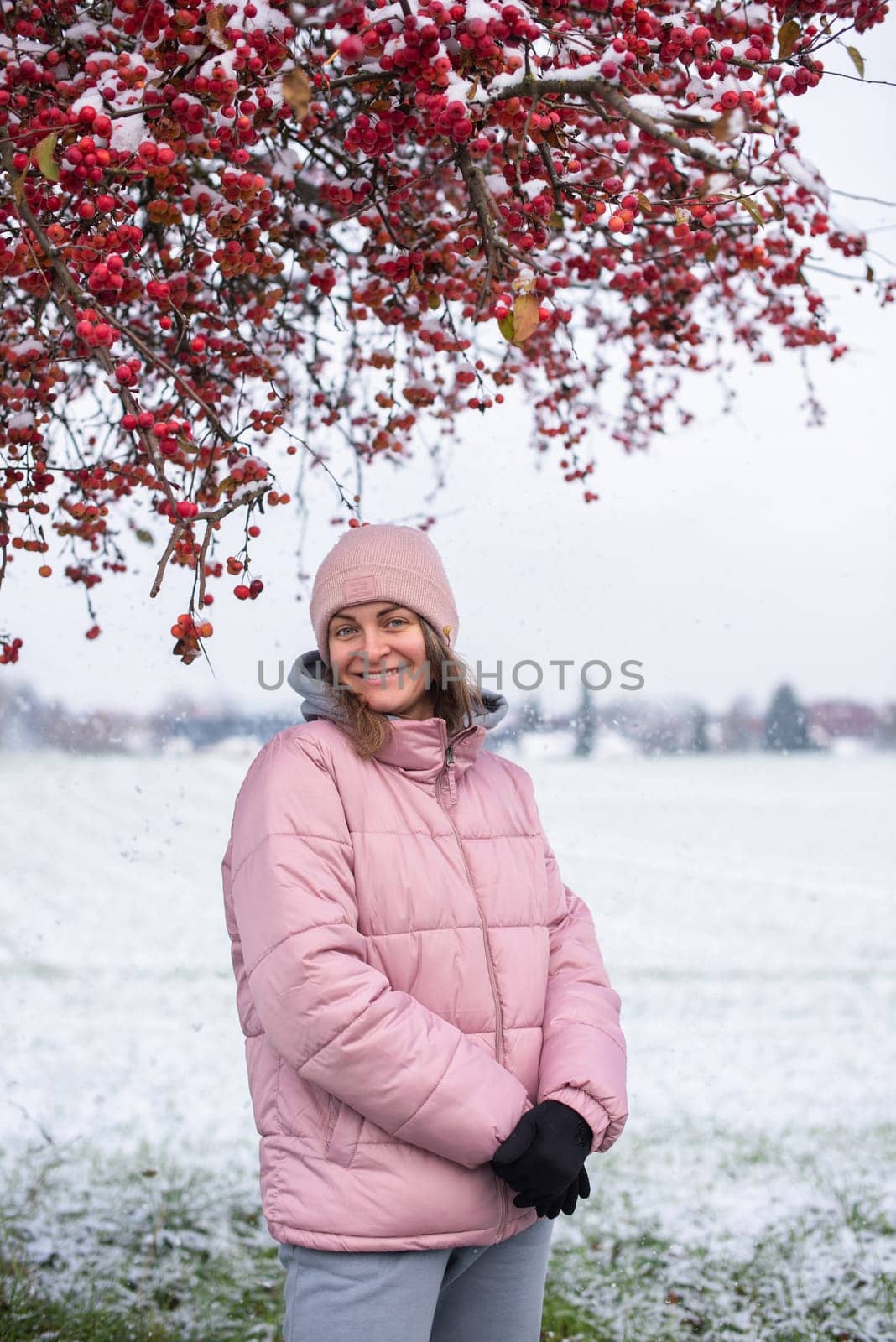 Winter Elegance: Portrait of a Beautiful Girl in a Snowy European Village. Winter lifestyle portrait of cheerful pretty girl. Smiling and having fun in the snow park. Snowflakes falling down. Christmas Radiance: Capturing Winter Elegance in the Snowy Ambiance of a European Village by Andrii_Ko