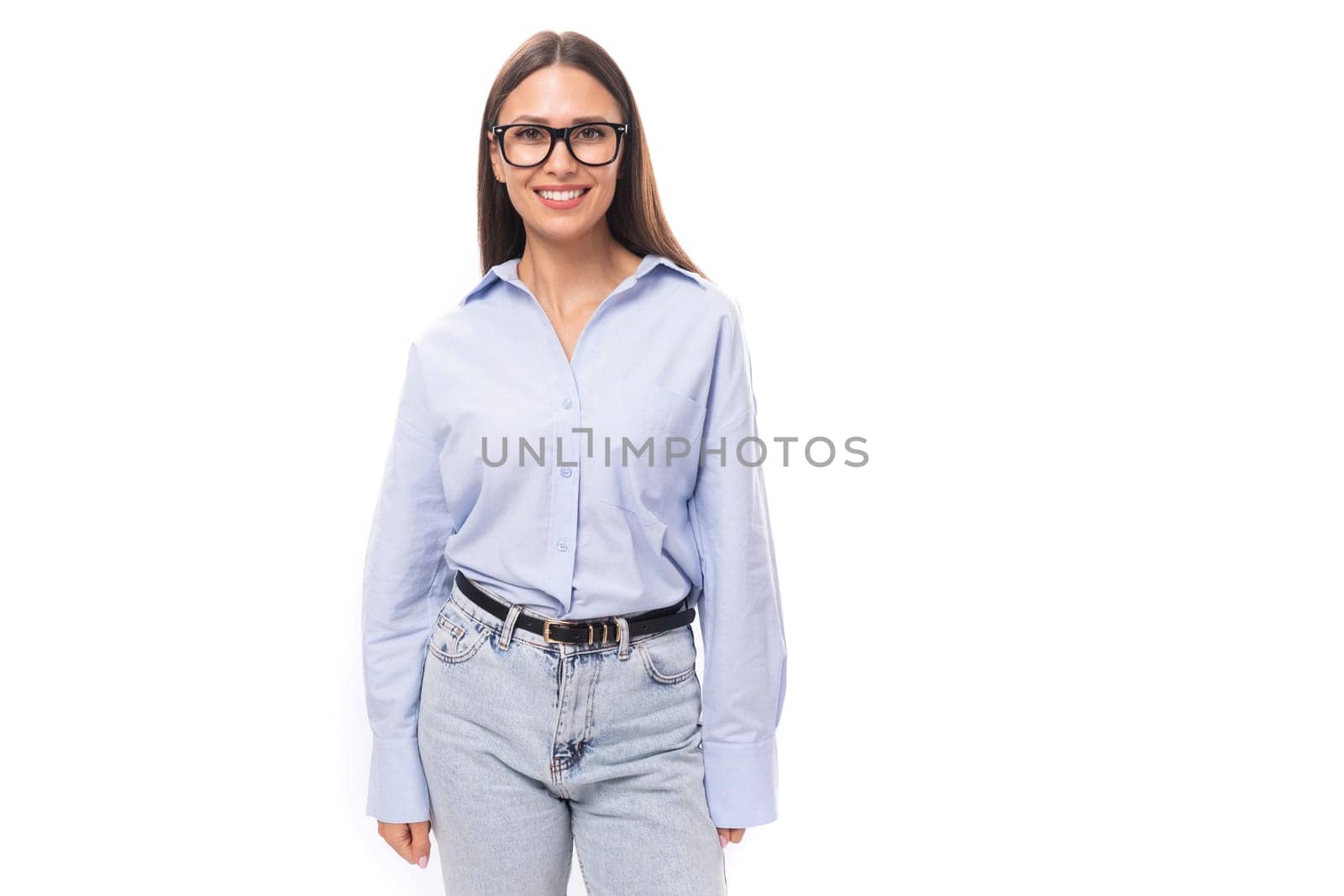 young pretty european business woman with long black hair dressed in a blue blouse and glasses on a white background with copy space.