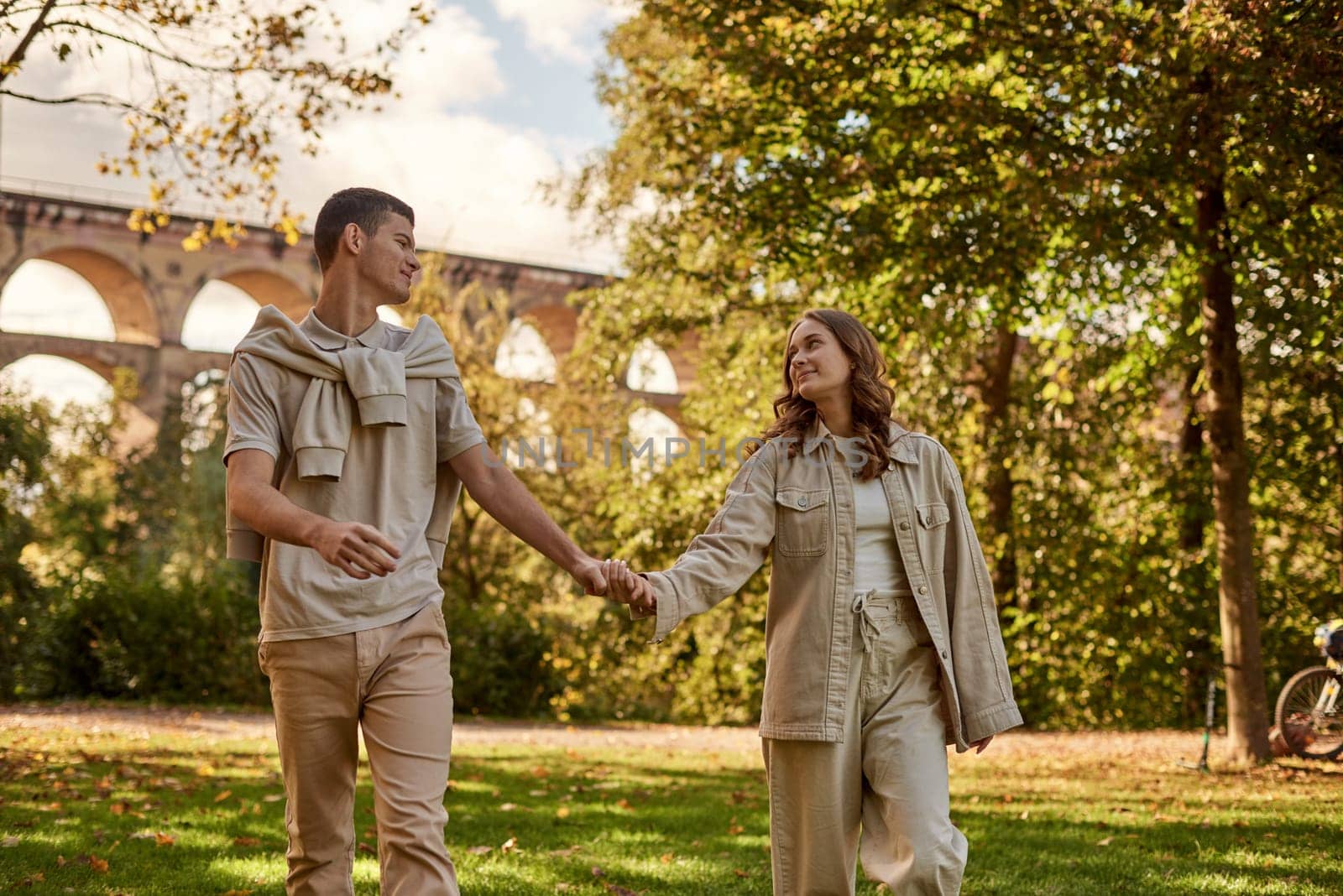 Young Cute Female Hugs Boyfriend. In Autumn Outdoor. Lovers Walking in Park. Attractive Funny Couple. Lovestory in Forest. Man and Woman. Cute Lovers in the Park. Family Concept. Happy Couple.