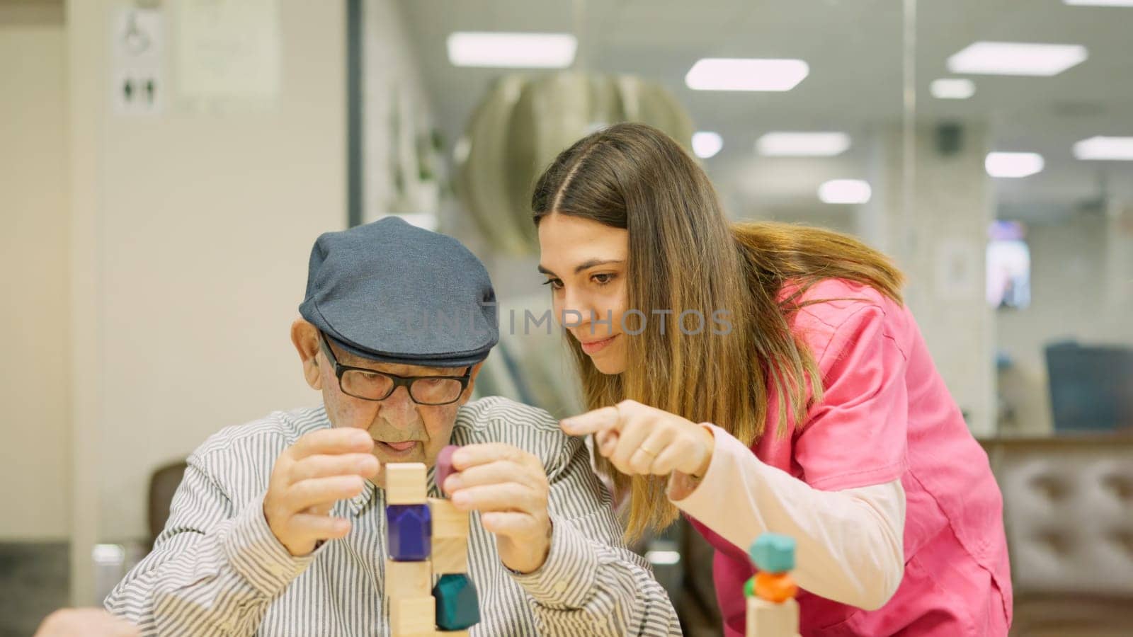 Friendly nurse helping a senior man to resolve a skill game