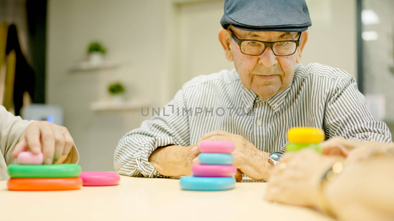 Senior man with beret looking at camera with serious look in a geriatrics