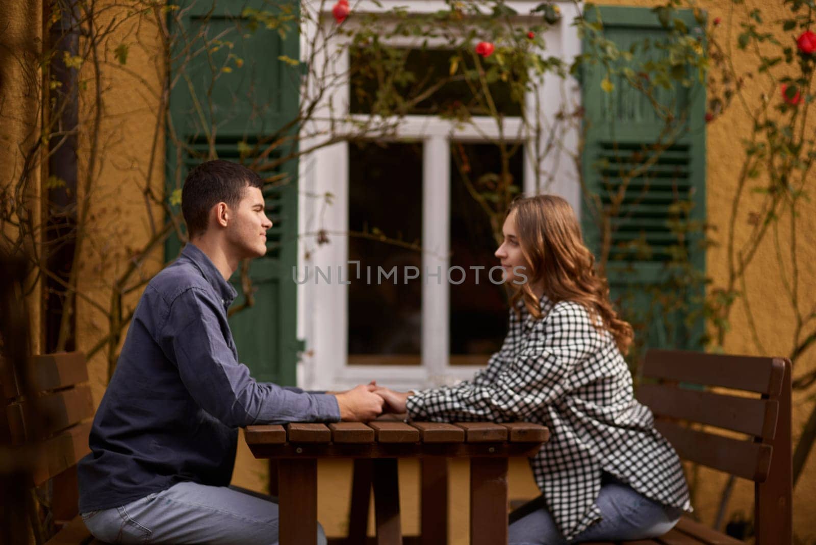 Teen Sweethearts: Holding Hands at an Outdoor Café in a European Town by Andrii_Ko