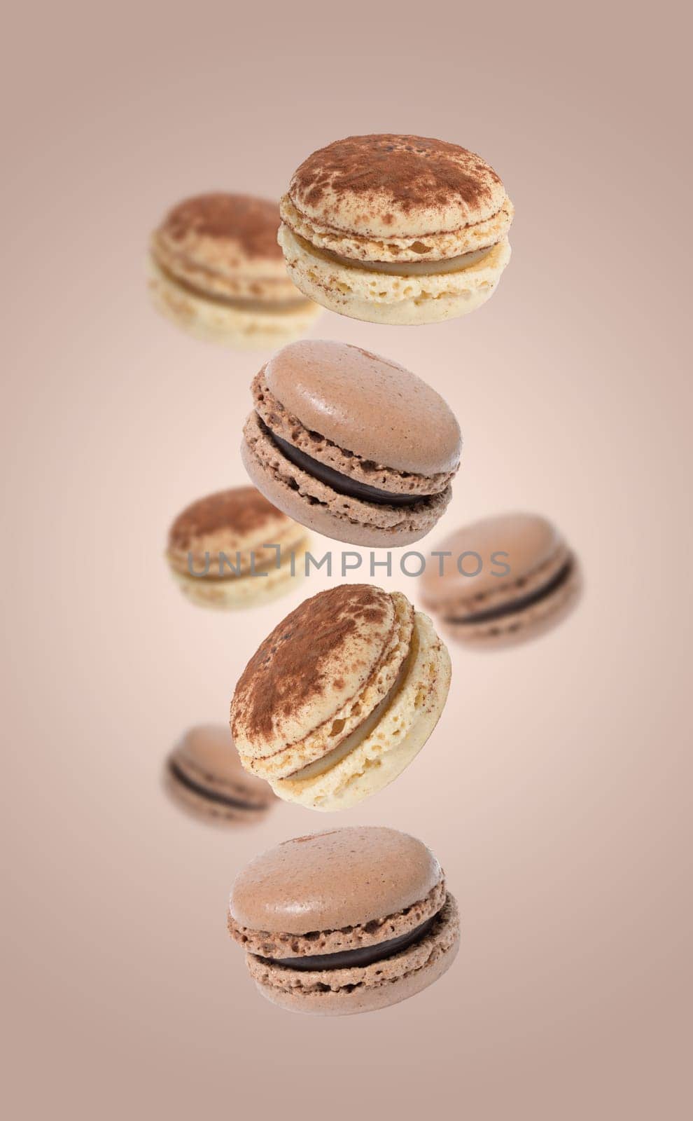 Chocolate macarons levitate on a light brown background, delicious dessert