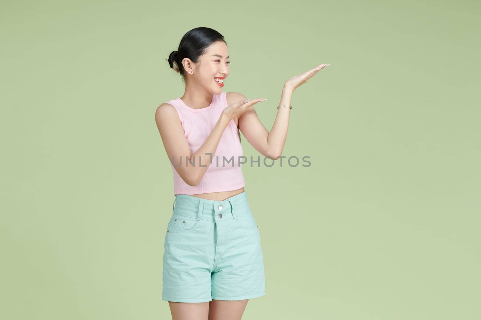 Asian happy young woman smile standing presenting product holding something on palm away side,