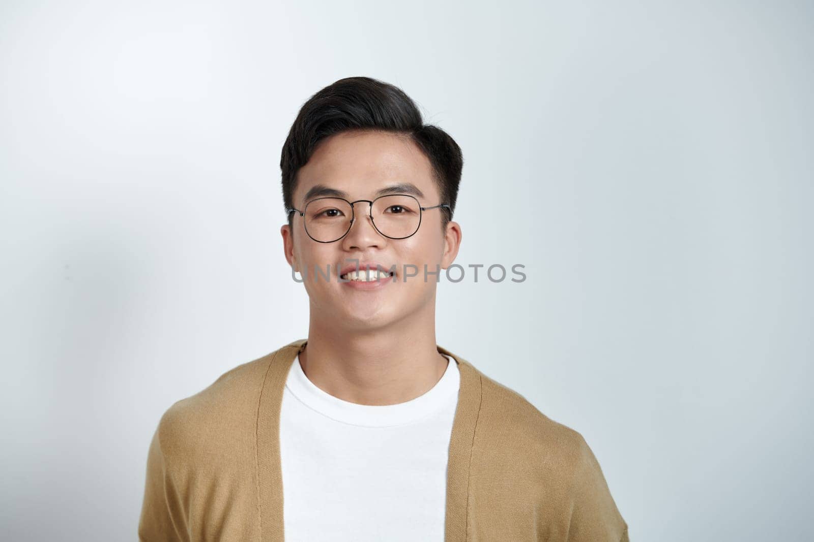 Close up portrait of young handsome Asian man face on light background
