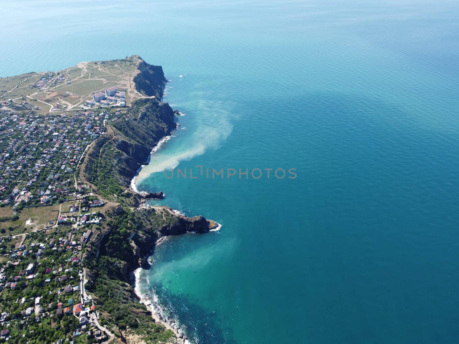 Aerial view from above on calm azure sea and volcanic rocky shores. Small waves on water surface in motion blur. Nature summer ocean sea beach background. Nobody. Holiday, vacation and travel concept by panophotograph