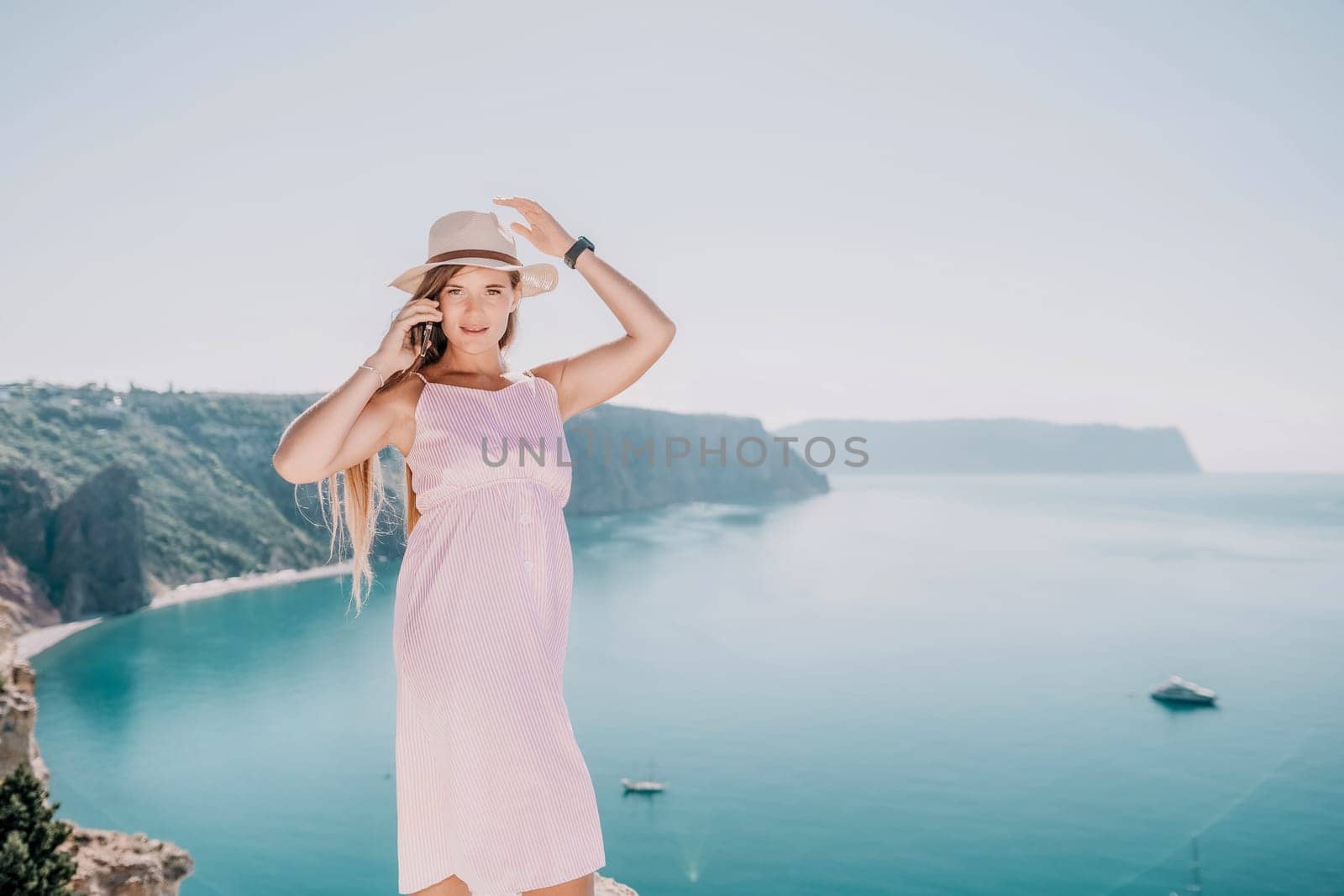 Woman sea laptop. Business woman in yellow hat freelancer with laptop working over blue sea beach. Girl relieves stress from work. Freelance, digital nomad, travel and holidays concept by panophotograph