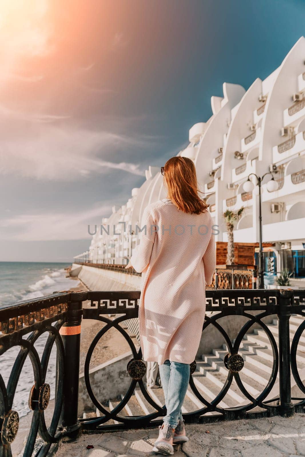 Woman summer travel sea. Happy tourist enjoy taking picture outdoors for memories. Carefree woman traveler posing on beach at sea on sunset, sharing travel adventure journey. Holiday vacation concept. by panophotograph