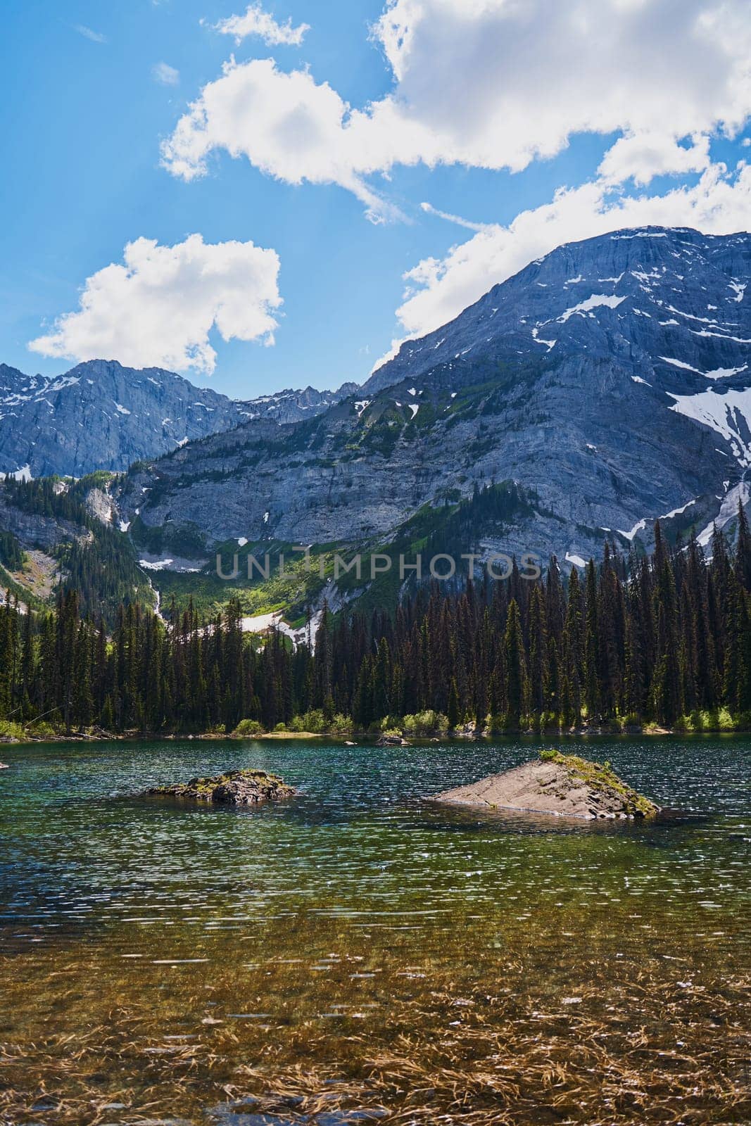 Incredibly beautiful transparent, emerald calm lake with reflection of rocky mountain on the Black Prince Cirque Trail. Majestic Canadian mountains with snow on sunny summer day in Alberta, Kananaskis by Try_my_best