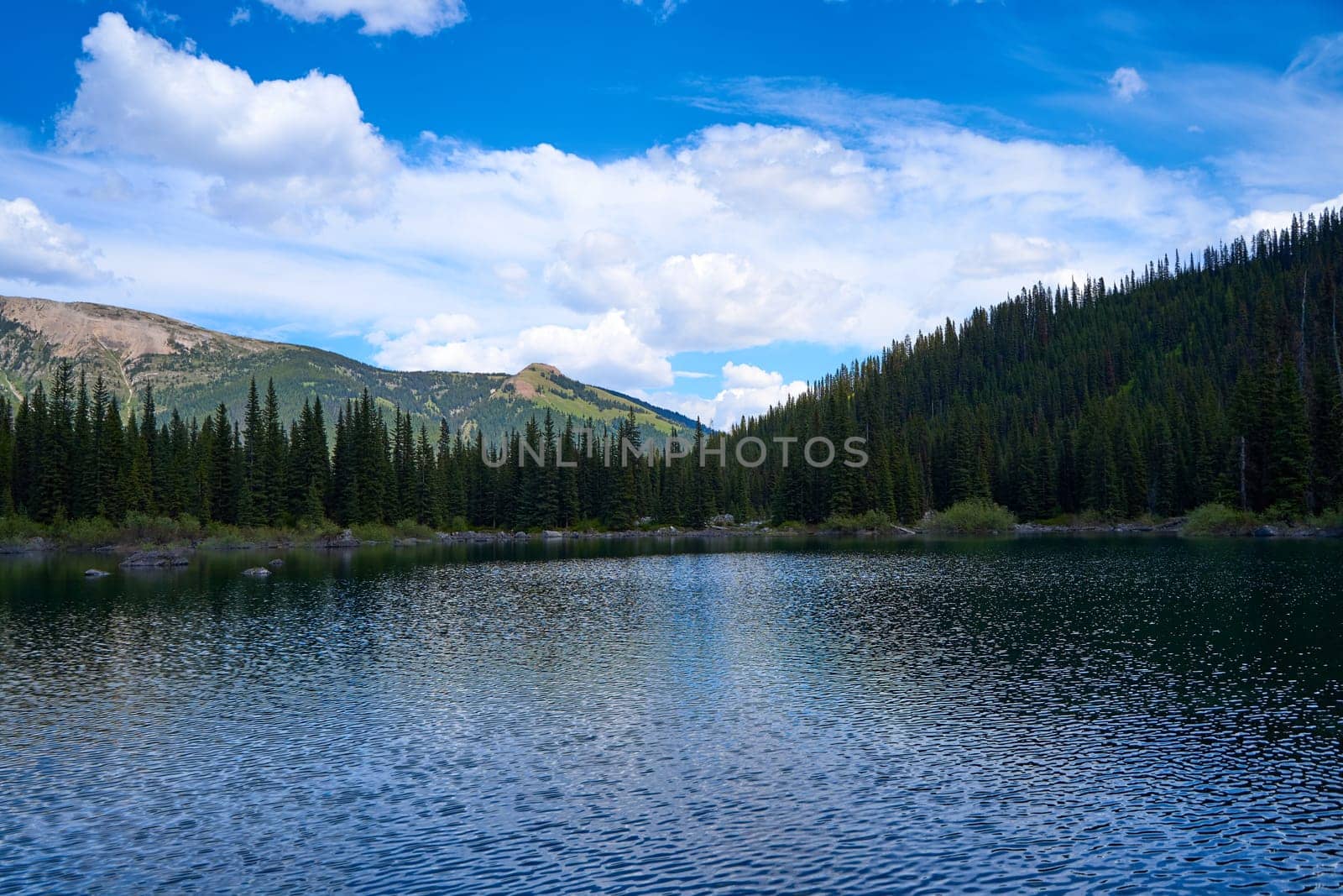 Incredibly beautiful transparent, emerald calm lake with reflection of rocky mountain on the Black Prince Cirque Trail. Majestic Canadian mountains with snow on sunny summer day in Alberta, Kananaskis by Try_my_best