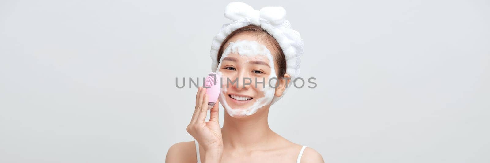 Panorama of asian female applying foamy cosmetic product on face during skincare routine by makidotvn