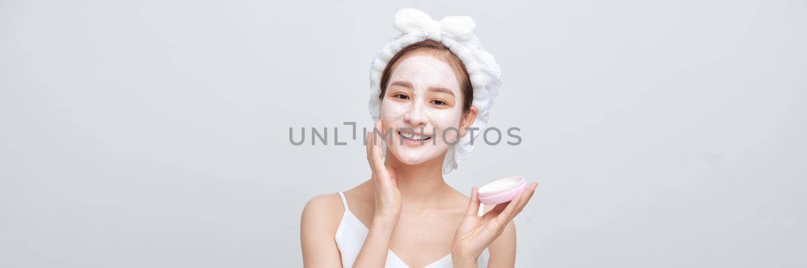 Beautiful Asian woman with facial mask on color banner background by makidotvn