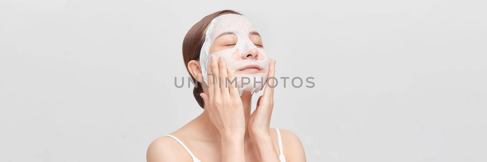 Beautiful young woman with sheet facial mask on color background. panorama