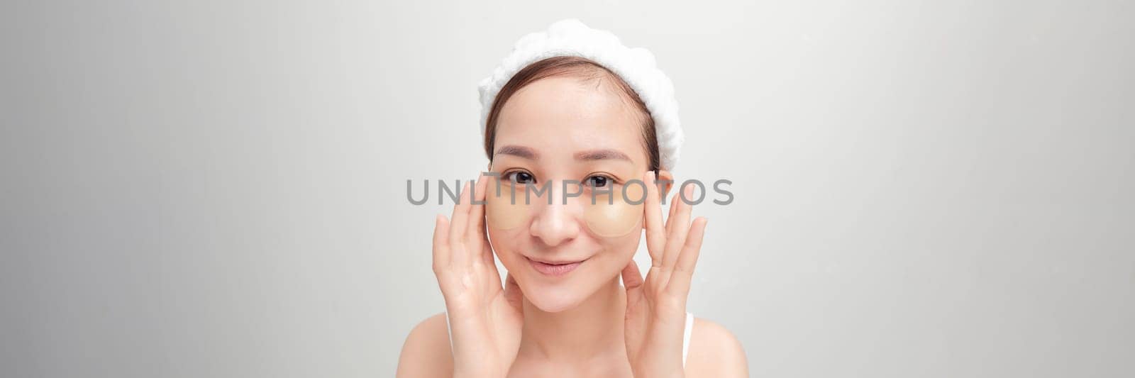 Surprised face woman touch patches under eyes isolated on white banner by makidotvn