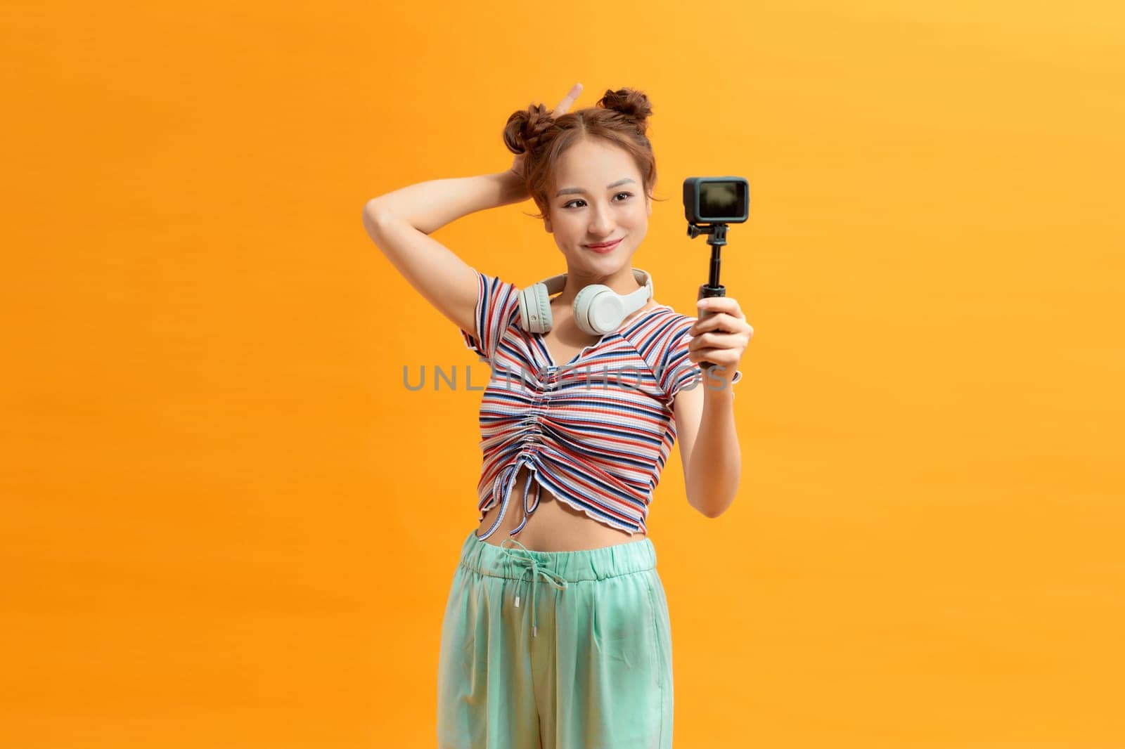 Young female blogger with recording video with gopro, making vlog.  by makidotvn
