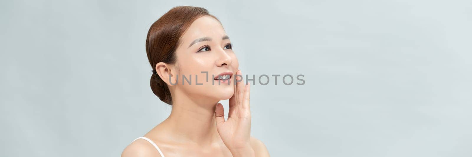 Asian woman has a lovely face is feeling happy with her perfect skin touch her face. Banner by makidotvn