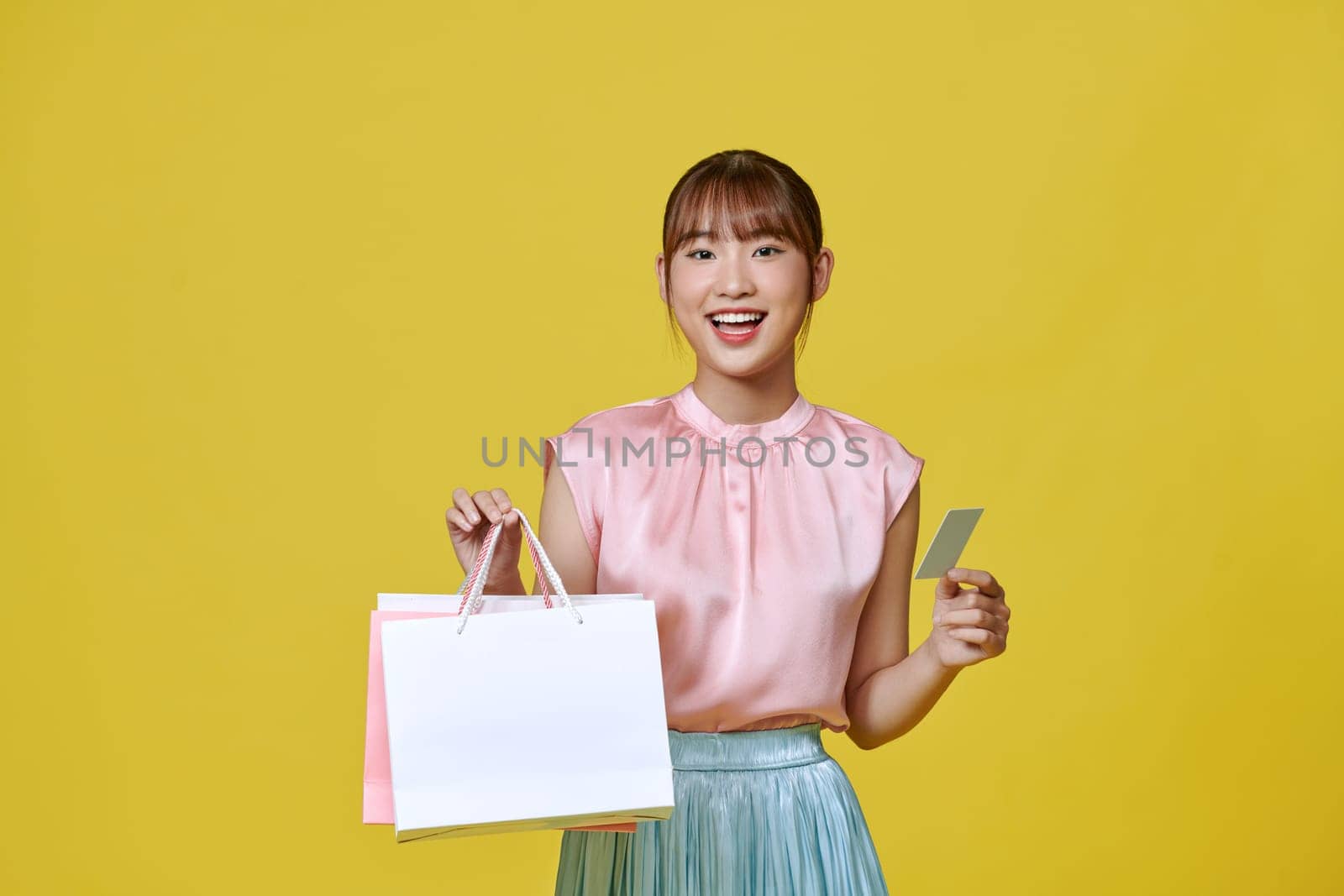 Asian happy female woman girl holds colourful shopping packages and cashless credit card payment