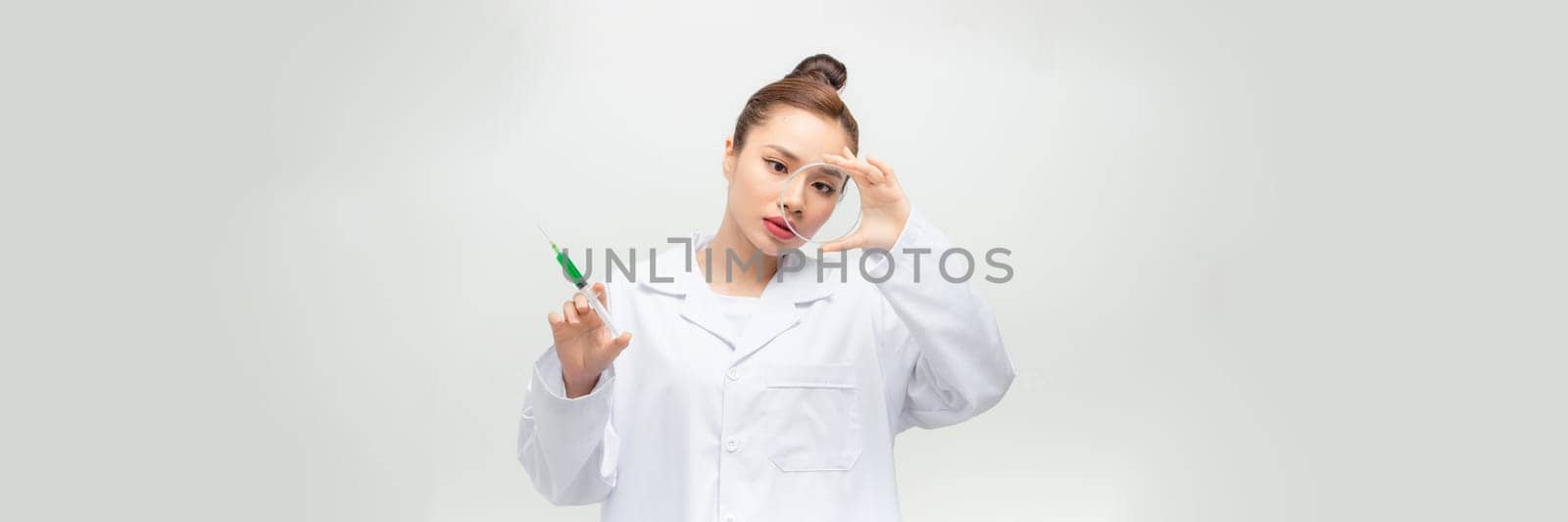 Woman holding a petri dish and a syringe, doctor.
