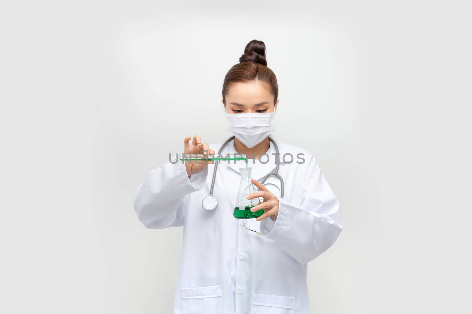 Female scientist in lab coat with chemical glassware. Isolated on white. by makidotvn