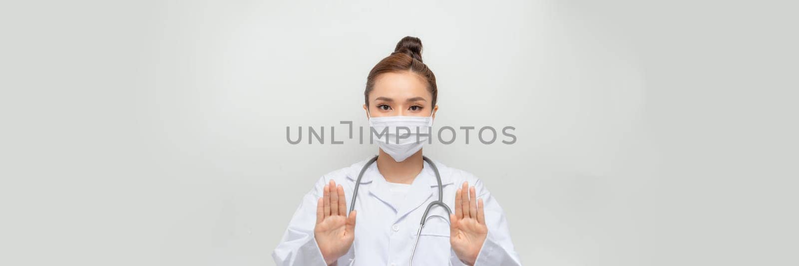 beauty female doctor in coat showing stop hand gesture