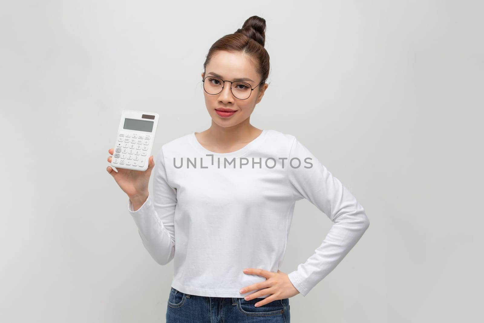 Happy young businesswoman showing calculator by makidotvn