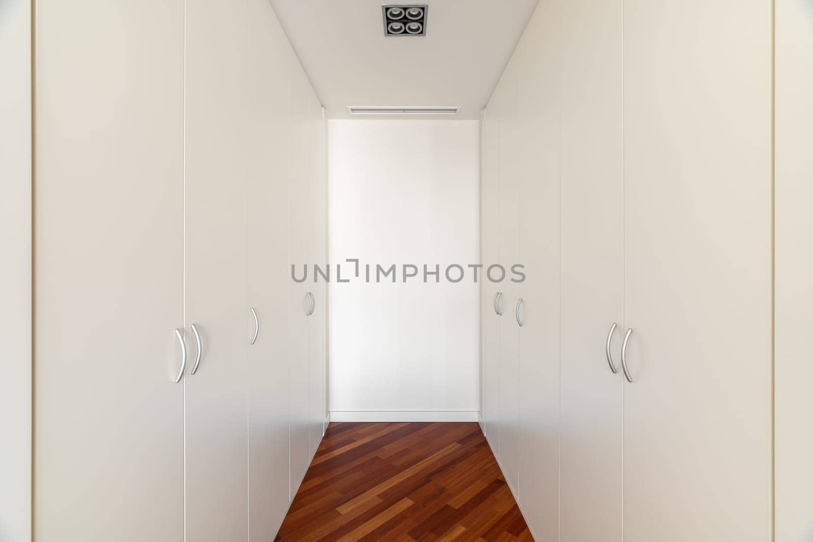 Dressing room area with built-in closets on both sides. Convenient place for storing clothes in one place in apartment. Good furniture solution