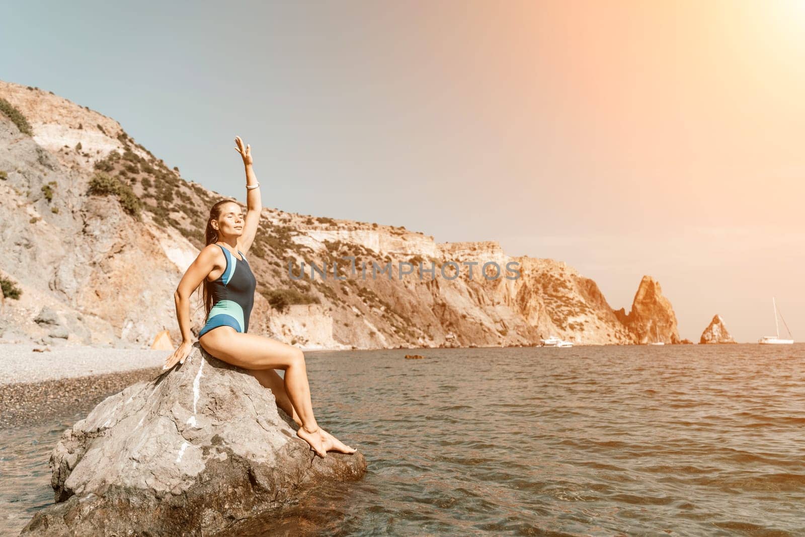 Woman travel summer sea. A happy tourist in a blue bikini enjoying the scenic view of the sea and volcanic mountains while taking pictures to capture the memories of her travel adventure