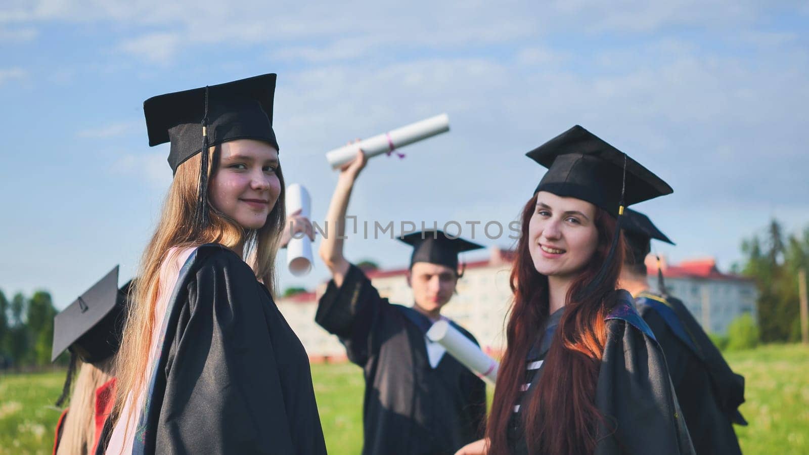 Portraits of graduating girls in black robes on the street