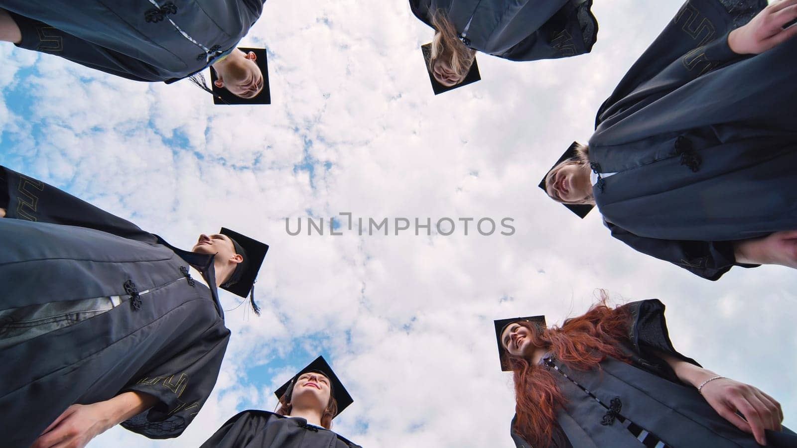 College students stand in a circle wearing black robes