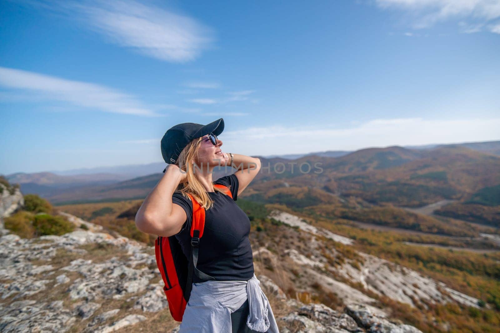 woman on mountain peak looking in beautiful mountain valley in autumn. Landscape with sporty young woman, blu sky in fall. Hiking. Nature by Matiunina