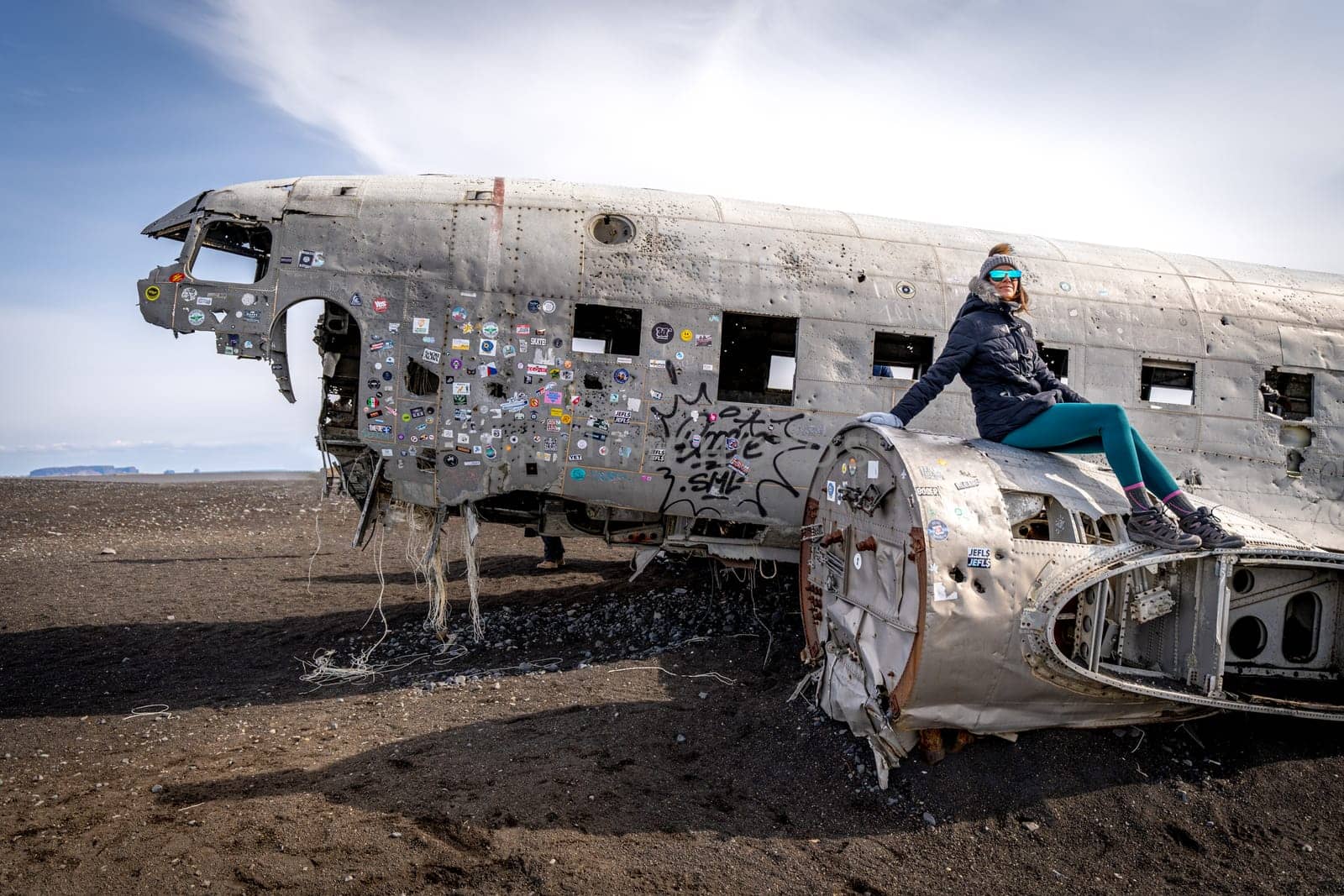 Woman posing in plane wreckage in Iceland