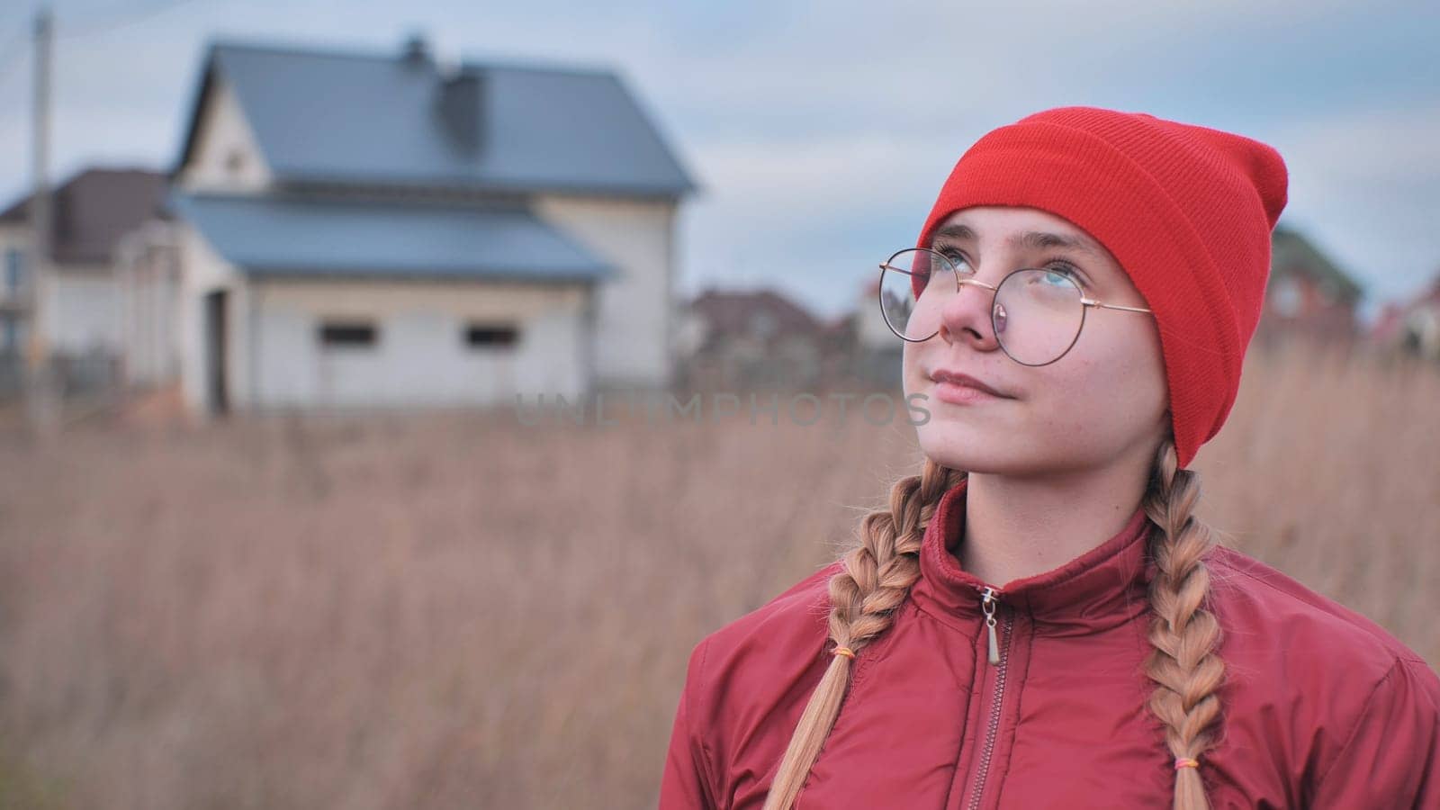 Portrait of a teenage girl in glasses wearing red clothes outside in the fall